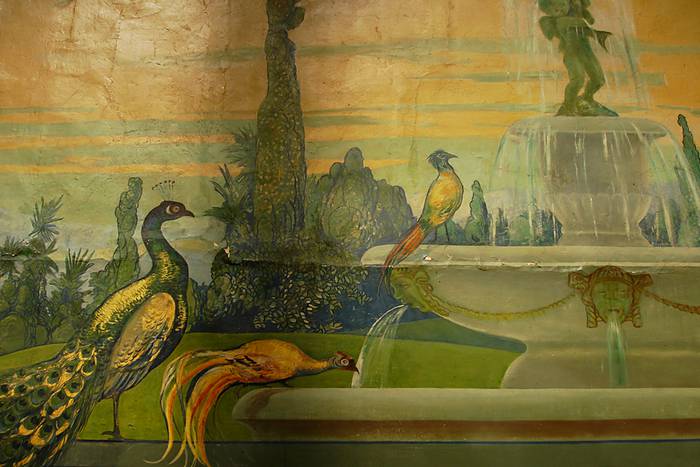 Malerei: Vögel trinken aus einem Brunnen.