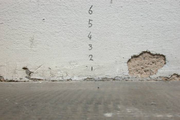 Zahlen von 6 bis 1 auf einer Wand übereinander geschrieben - 6 zuoberst.